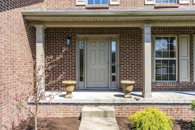 property entrance featuring brick siding and covered porch