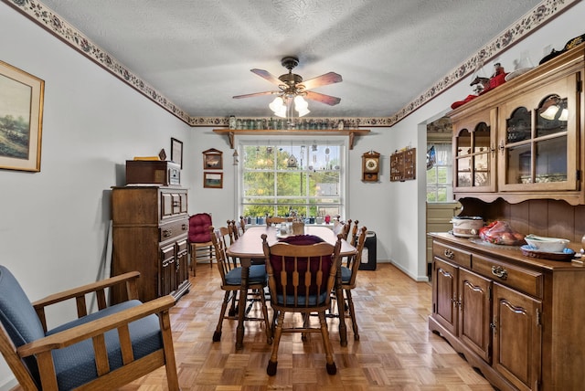 dining area with a ceiling fan, a textured ceiling, and a wealth of natural light
