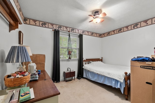 bedroom featuring a textured ceiling, light carpet, and ceiling fan