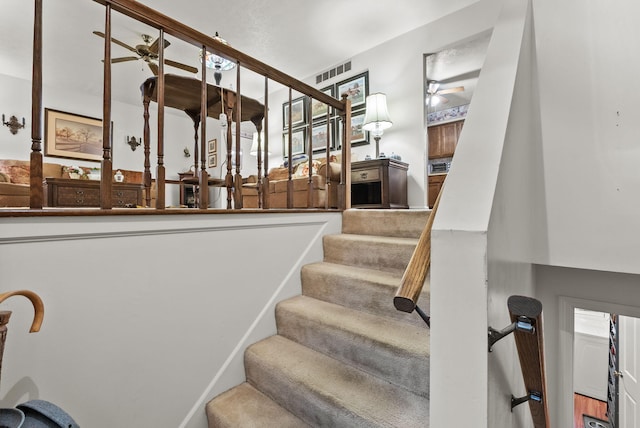 stairs featuring a ceiling fan and visible vents