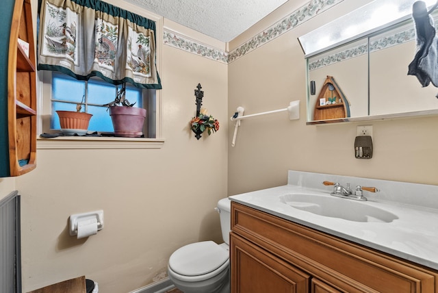 bathroom featuring vanity, a textured ceiling, and toilet