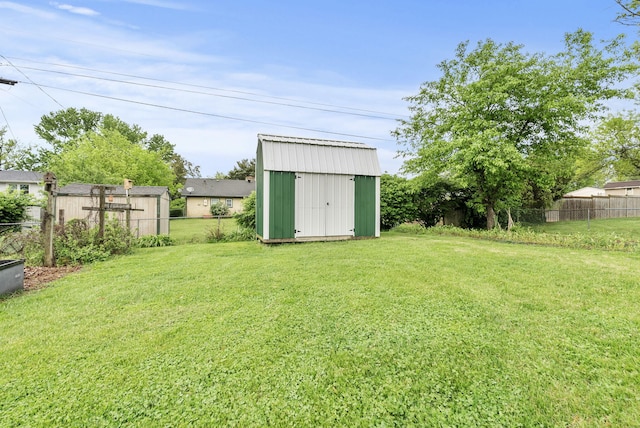 view of yard featuring an outdoor structure, a shed, and fence