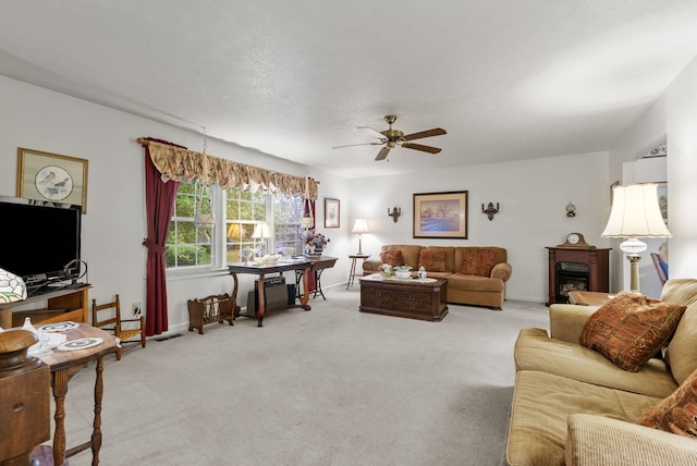 living area featuring a ceiling fan, baseboards, visible vents, and light carpet