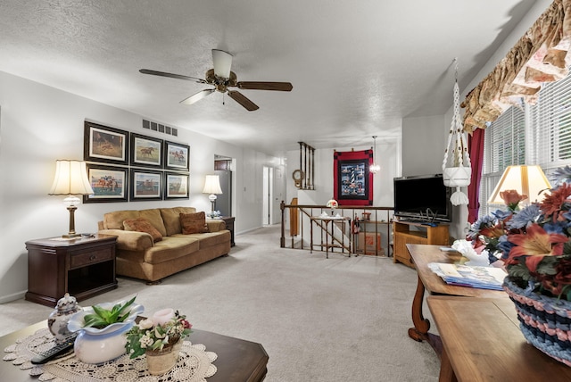 living area featuring visible vents, carpet flooring, and ceiling fan