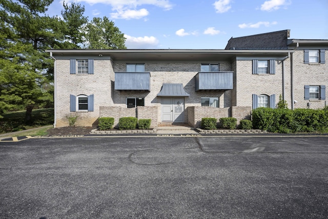 view of front of property featuring brick siding and uncovered parking
