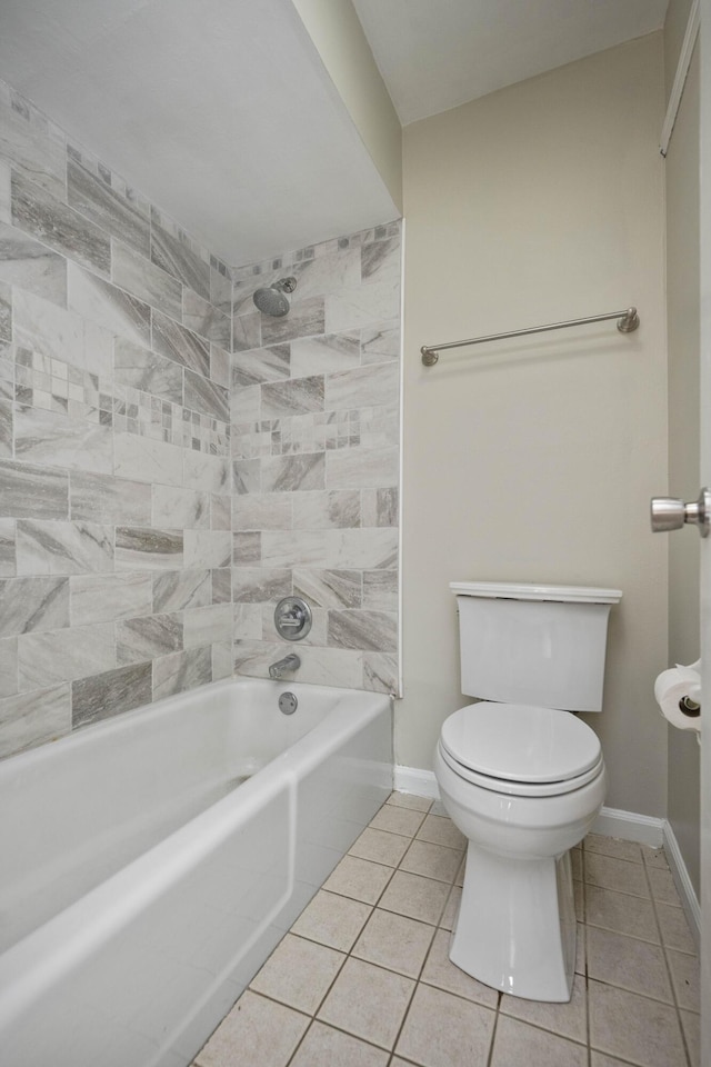 bathroom featuring toilet, tub / shower combination, baseboards, and tile patterned flooring