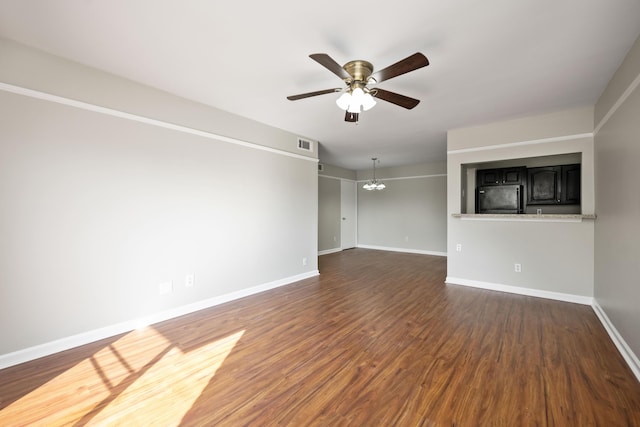 unfurnished room with dark wood-style flooring, ceiling fan with notable chandelier, baseboards, and visible vents