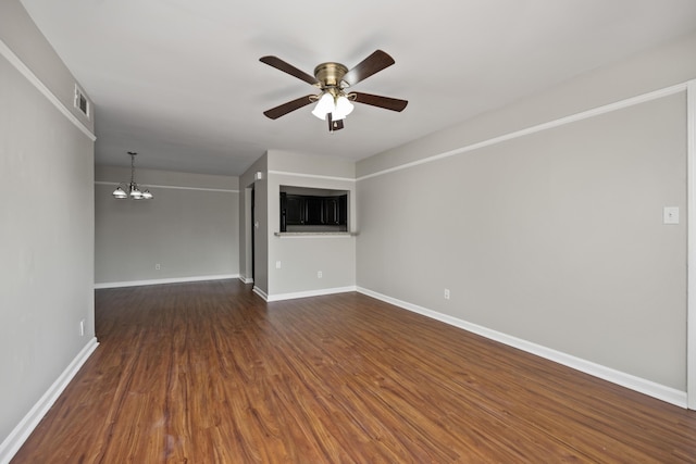 unfurnished living room featuring visible vents, ceiling fan with notable chandelier, baseboards, and dark wood finished floors
