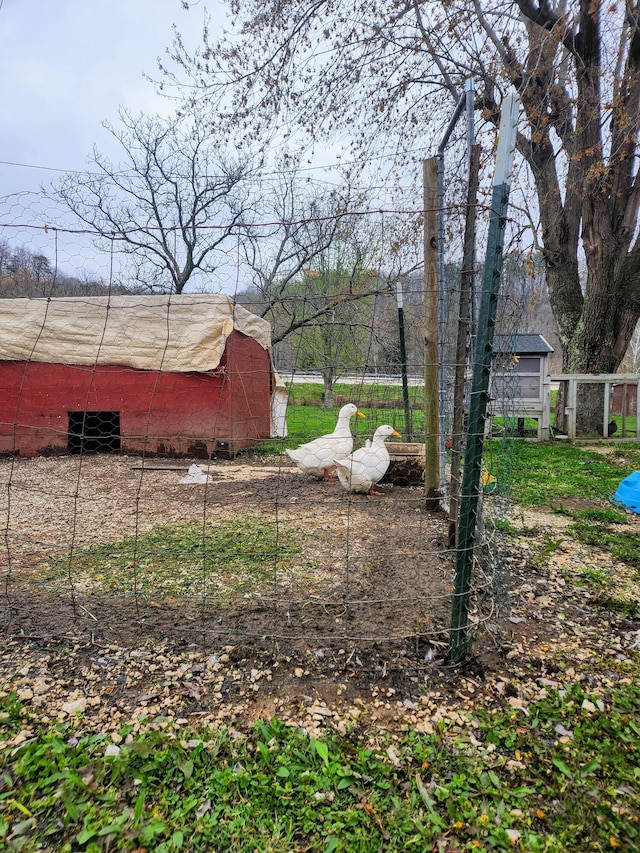 view of yard with an outbuilding, a barn, and fence
