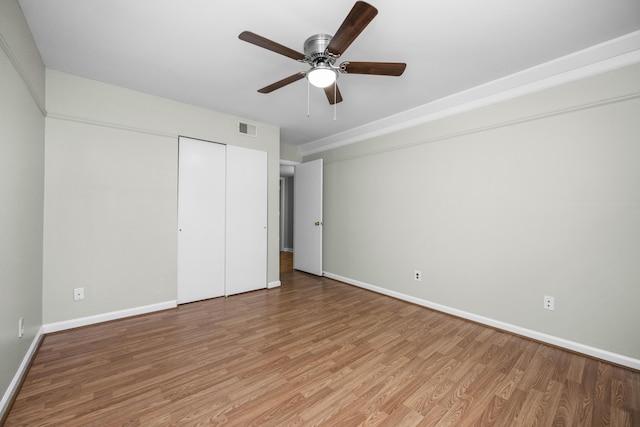 unfurnished bedroom featuring visible vents, baseboards, a closet, a ceiling fan, and light wood finished floors