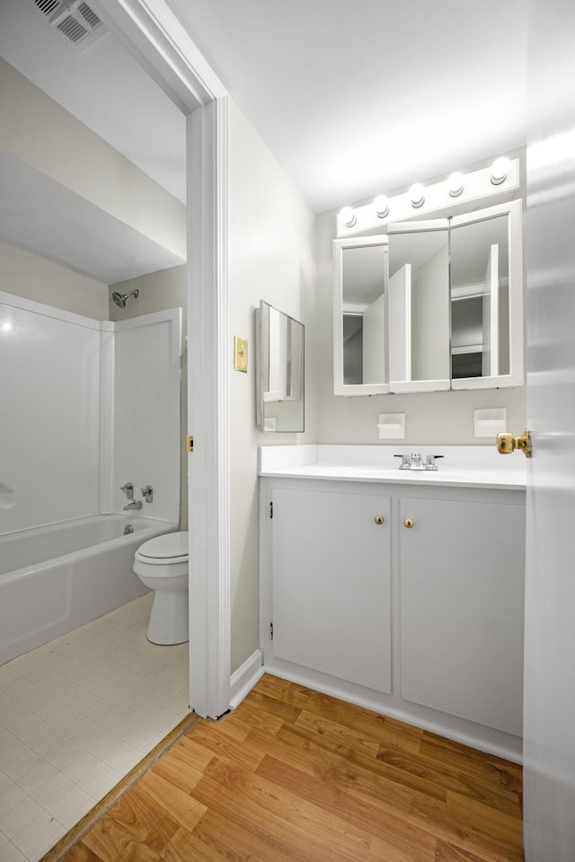 full bathroom with vanity, baseboards, bathing tub / shower combination, toilet, and visible vents
