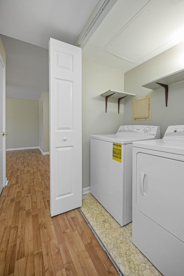laundry area with light wood-style flooring, laundry area, baseboards, and washer and clothes dryer