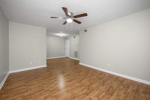 empty room featuring visible vents, light wood-type flooring, and ceiling fan