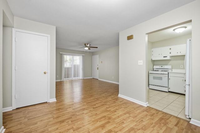 unfurnished living room featuring light wood-style flooring, baseboards, and a ceiling fan