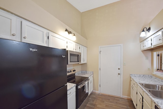 kitchen with dark wood-type flooring, white cabinetry, a sink, and appliances with stainless steel finishes