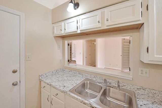 kitchen featuring a sink and white cabinets