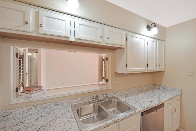 kitchen with a sink, light countertops, stainless steel dishwasher, and white cabinetry