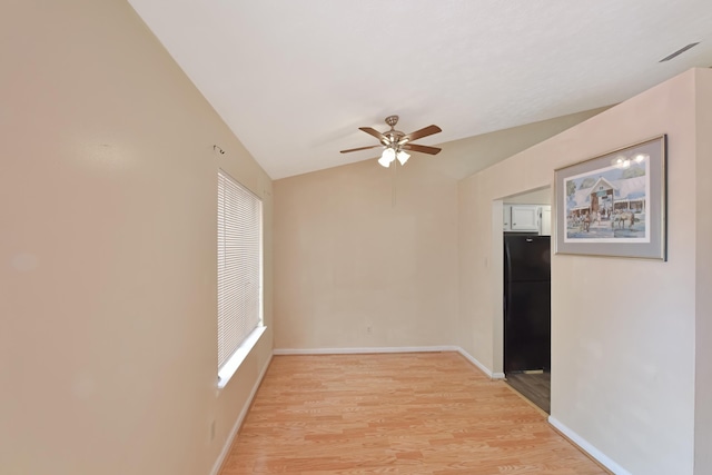 spare room featuring baseboards, a ceiling fan, light wood-style floors, and lofted ceiling