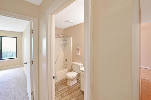bathroom with visible vents, toilet, wood finished floors, and  shower combination