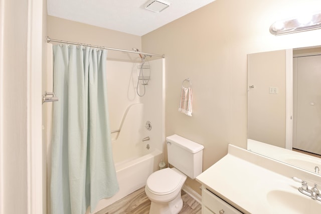 bathroom featuring vanity, visible vents, toilet, shower / bath combo, and wood finished floors
