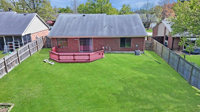 back of house with a yard, a deck, and brick siding