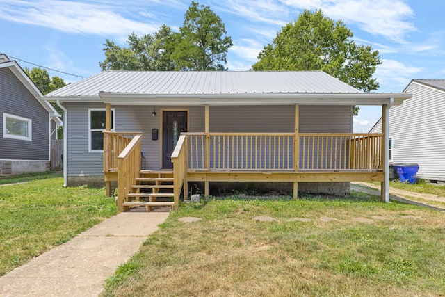 view of front of house with a porch, metal roof, and a front lawn