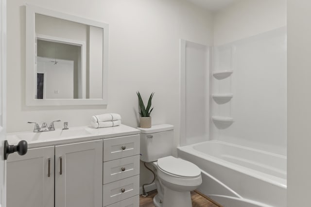 bathroom with washtub / shower combination, vanity, toilet, and wood finished floors