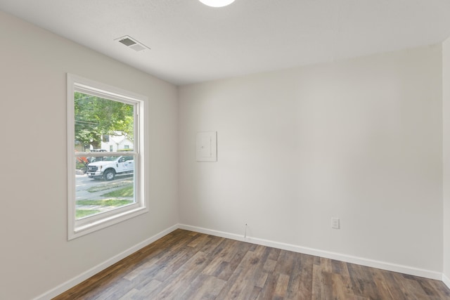 empty room with visible vents, baseboards, and wood finished floors