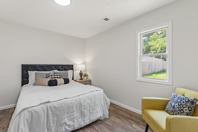 bedroom featuring visible vents, baseboards, and wood finished floors
