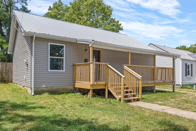 view of front of property with a front lawn, fence, and metal roof