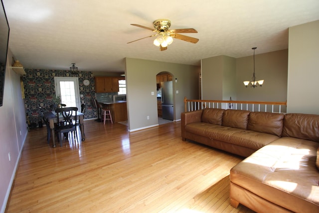 312 Springhurst Dr, Berea, KY 40403 - living area featuring baseboards, arched walkways, light wood finished floors, and ceiling fan with notable chandelier