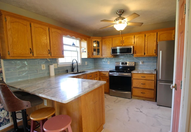 312 Springhurst Dr, Berea, KY 40403 - kitchen with appliances with stainless steel finishes, brown cabinets, a sink, a peninsula, and marble finish floor