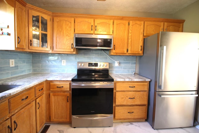 312 Springhurst Dr, Berea, KY 40403 - kitchen with backsplash, brown cabinets, appliances with stainless steel finishes, and glass insert cabinets