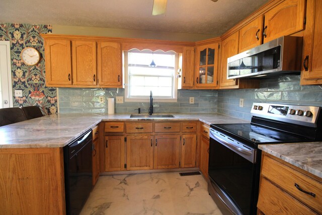312 Springhurst Dr, Berea, KY 40403 - kitchen featuring marble finish floor, a peninsula, brown cabinets, a sink, and appliances with stainless steel finishes