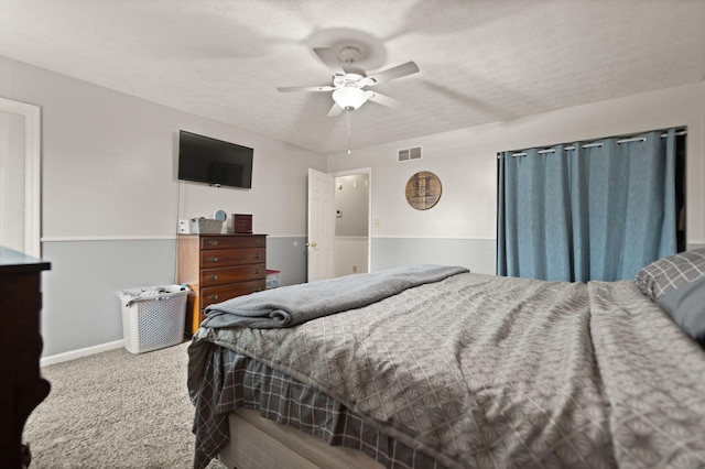 carpeted bedroom with visible vents, baseboards, and ceiling fan