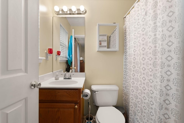 bathroom with vanity, curtained shower, and toilet