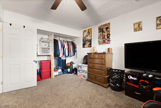 bedroom with a ceiling fan, a textured ceiling, carpet, and a closet