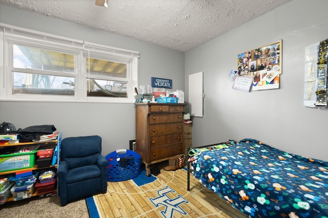 bedroom featuring a textured ceiling and multiple windows