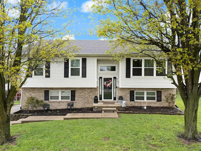 bi-level home with a front yard and brick siding
