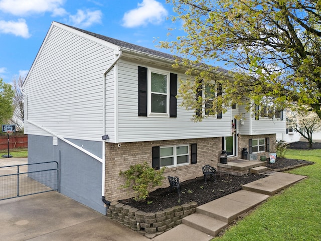 view of front of home featuring brick siding and fence