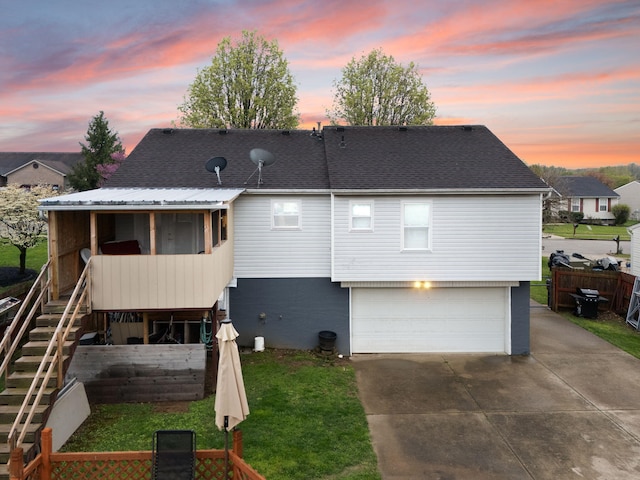 back of house featuring a garage, fence, driveway, stairs, and a yard