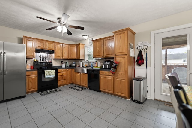 kitchen featuring ceiling fan, a sink, tasteful backsplash, under cabinet range hood, and black appliances