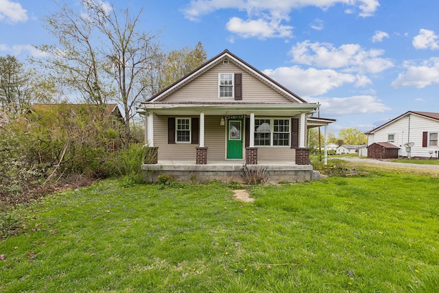 bungalow with a porch and a front lawn