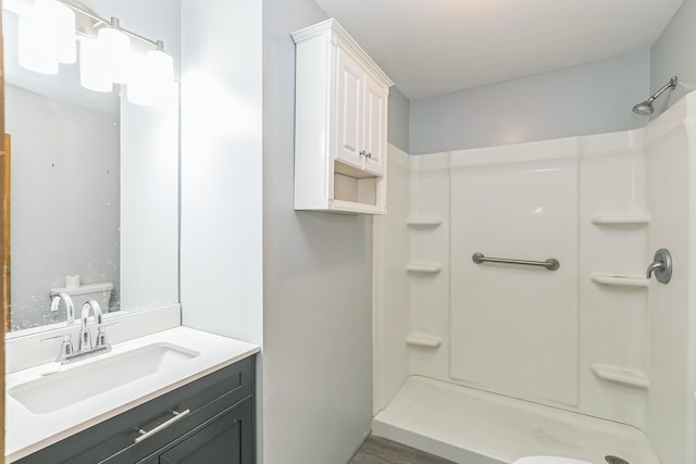 full bath with wood finished floors, vanity, and walk in shower