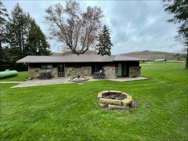 1459 Buck Lick Rd, Tollesboro, KY 41189 - back of property with stone siding, a fire pit, a patio, and a lawn