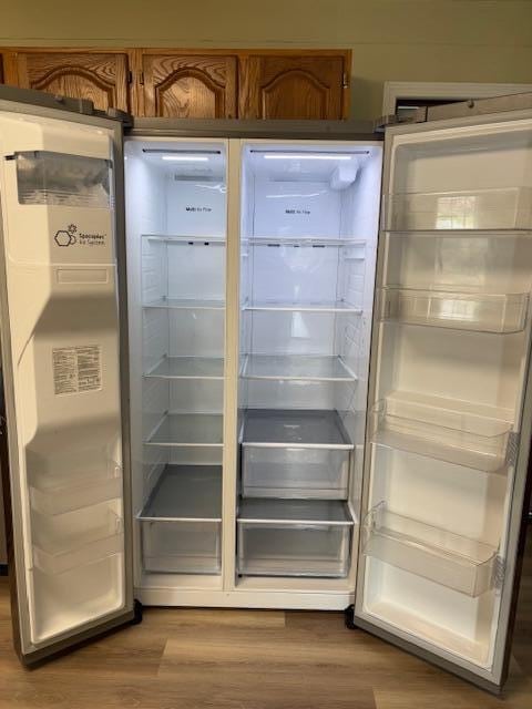 room details featuring wood finished floors and refrigerator