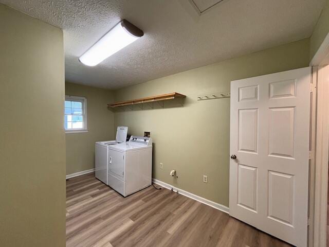 washroom featuring washer and dryer, light wood-type flooring, laundry area, and baseboards