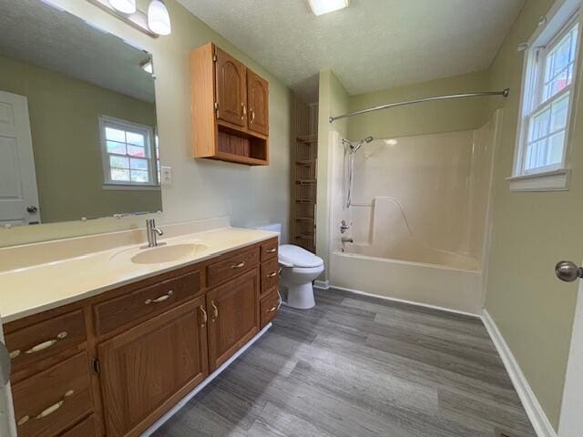 full bath with vanity, bathtub / shower combination, toilet, and wood finished floors