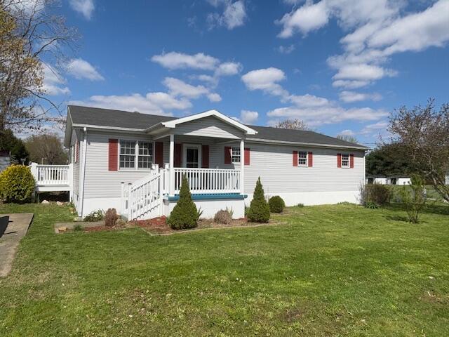 ranch-style home with a front lawn and covered porch