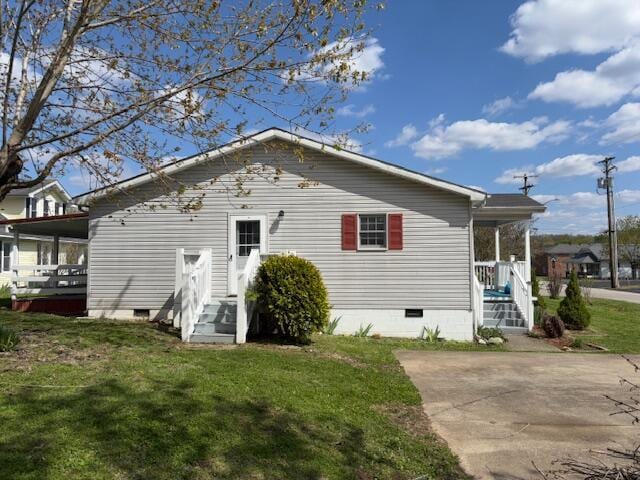 rear view of property featuring a lawn and crawl space